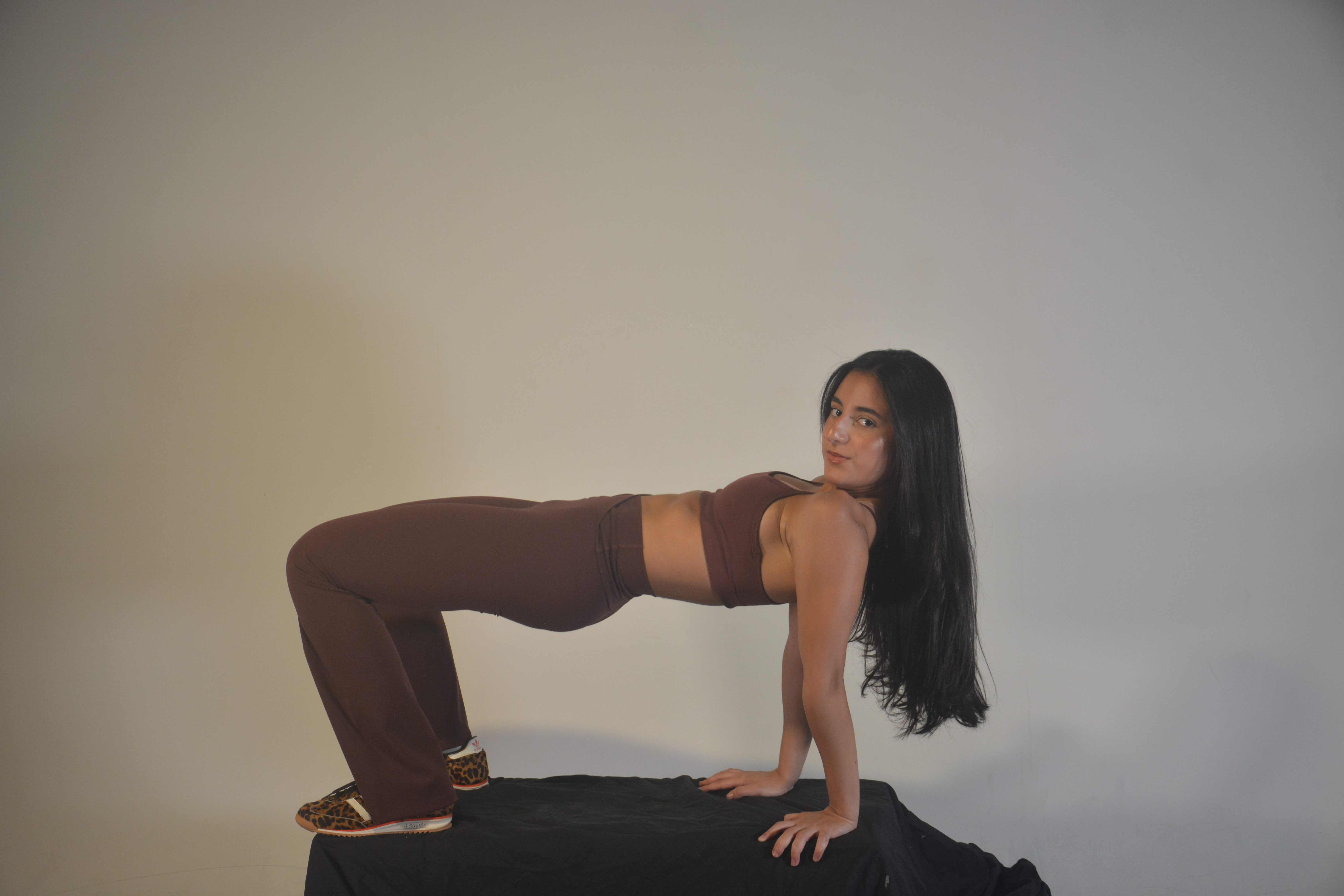 Mujer en ropa deportiva estirando en un estudio minimalista